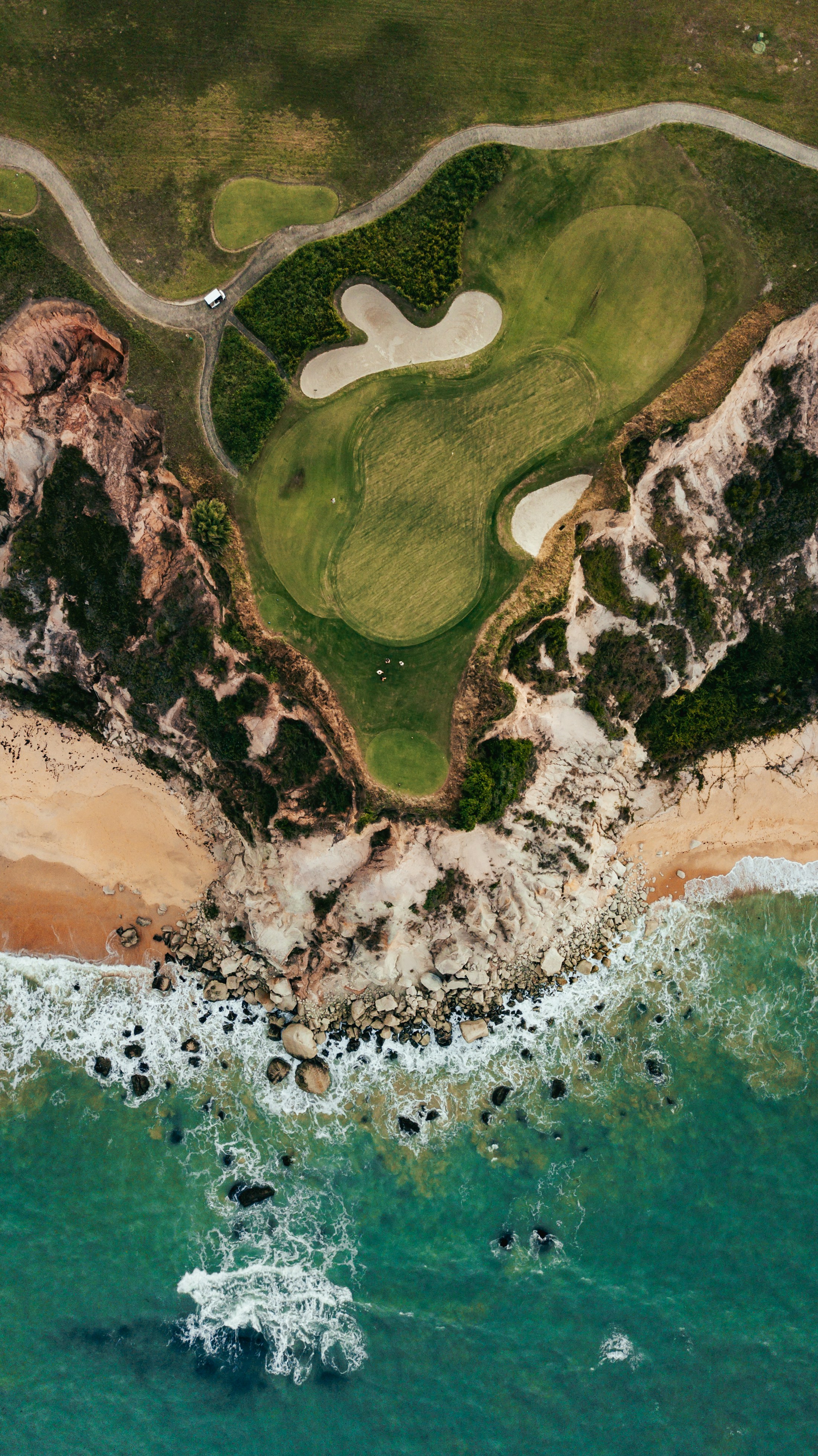 Aerial view of a golf green surrounded by fairway and bunkers